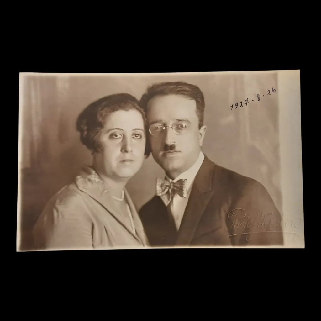 Sepia studio portrait of a man in glasses and a bow tie with a woman