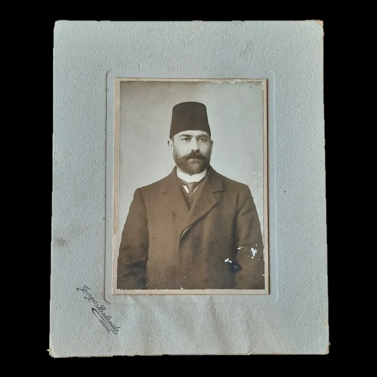 Studio portrait of the bearded, fez-wearing President of the Yanya Civil Court, mounted on gray card