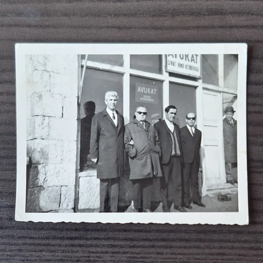 'Avukat Cevdet Hamdi Kethüdaoğlu' tabelalı yazıhane önünde poz veren paltolu ve takım elbiseli adamlar