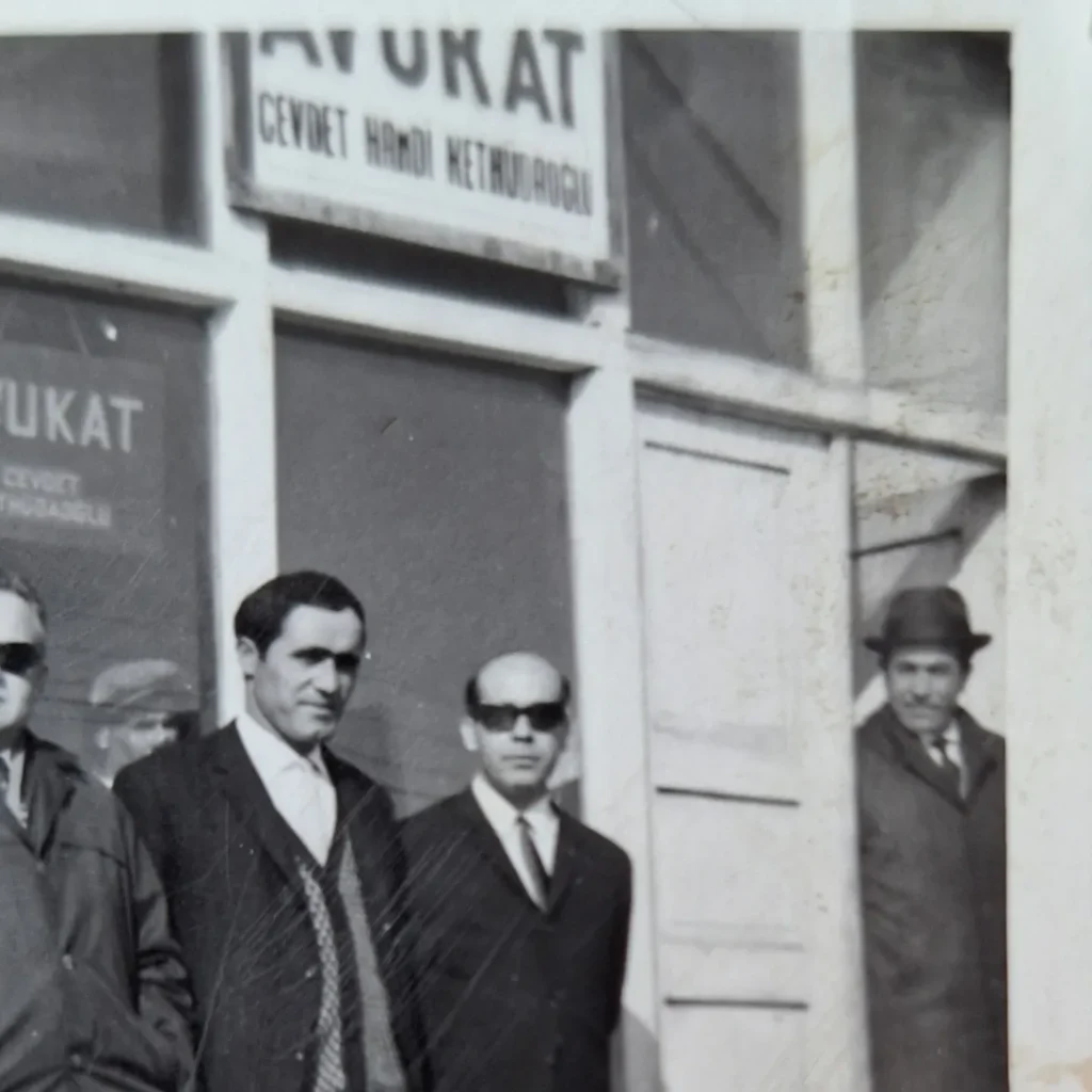 Yazıhane tabelası ve kapı önündeki şapkalı adamın detay görüntüsü