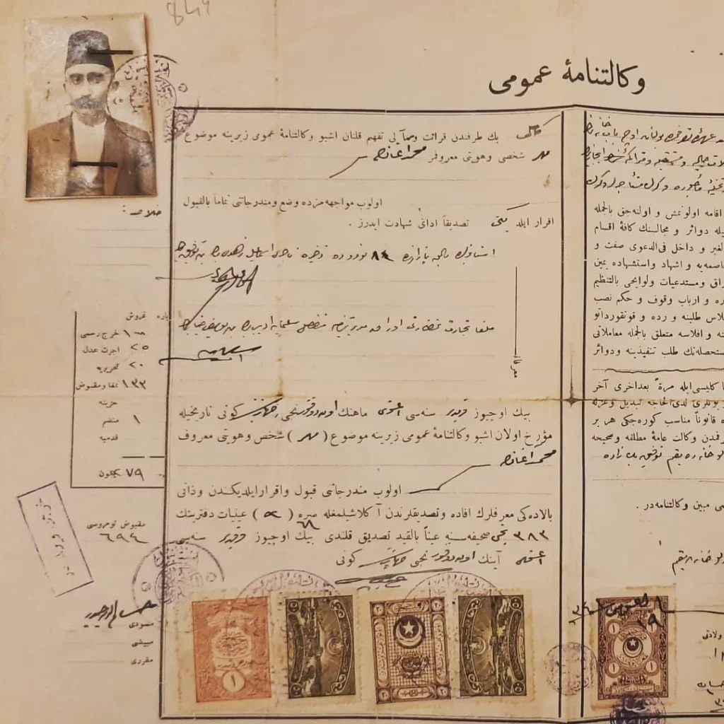 Fesli bir adamın fotoğrafı iliştirilmiş, pullu ve mühürlü Osmanlıca genel vekâletname