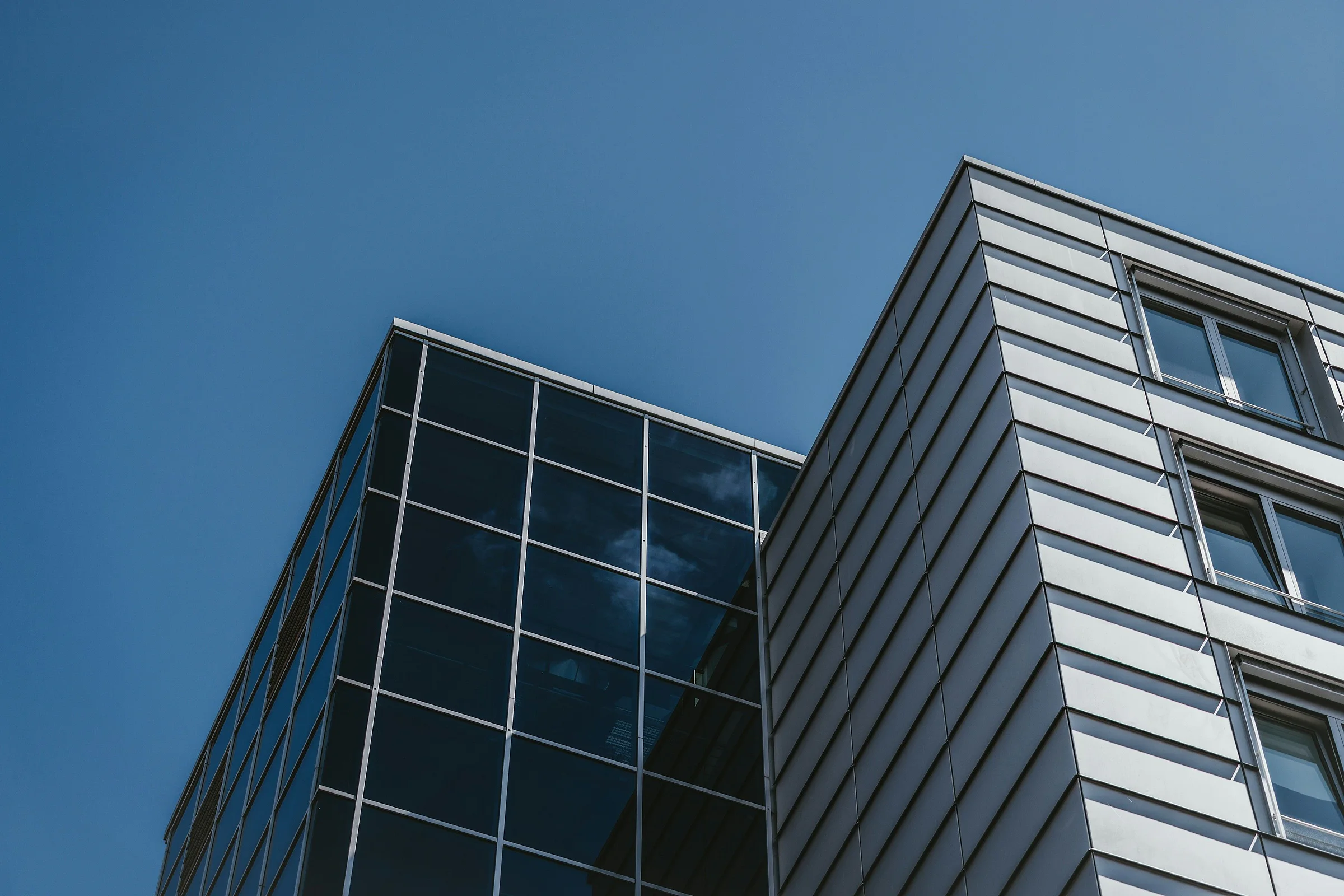 Modern office building with a glass and aluminum facade against a navy-blue sky