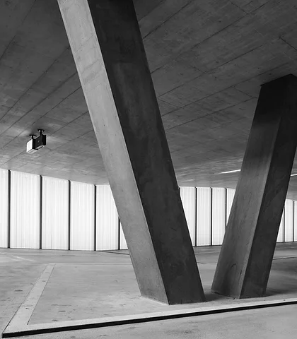 Parking garage level with V-shaped concrete columns, black and white