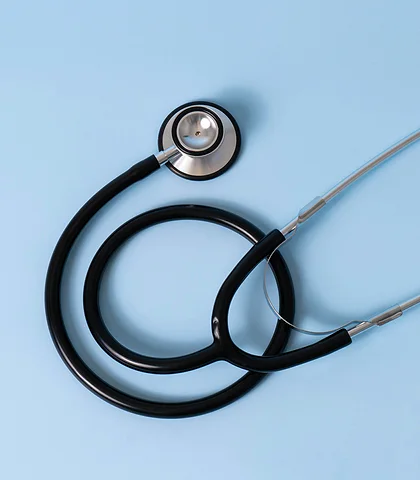 A coiled black stethoscope on a light blue background
