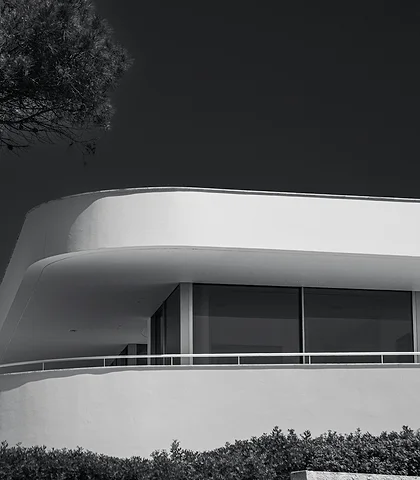 Curved white modern villa against a dark sky, black and white