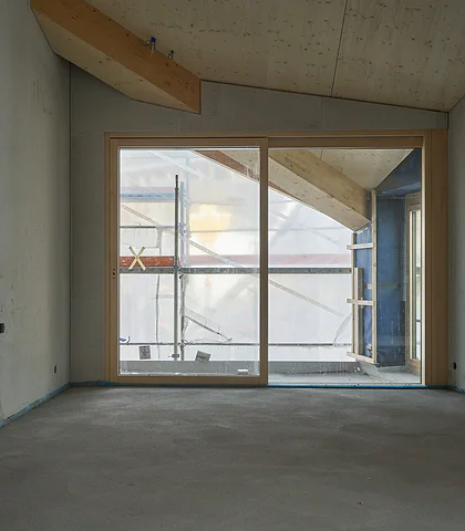 Interior of an unfinished apartment with a screed floor and plastered walls