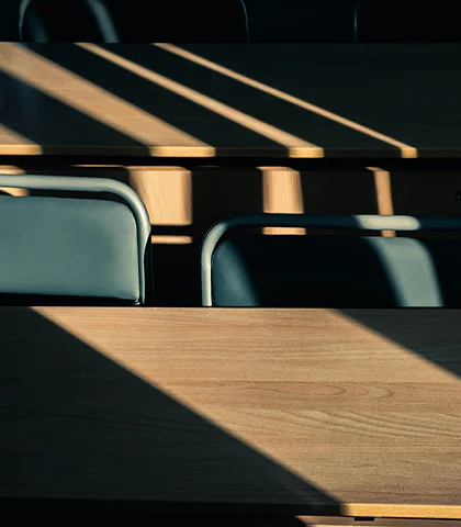 Empty tables and chairs crossed by bands of sunlight