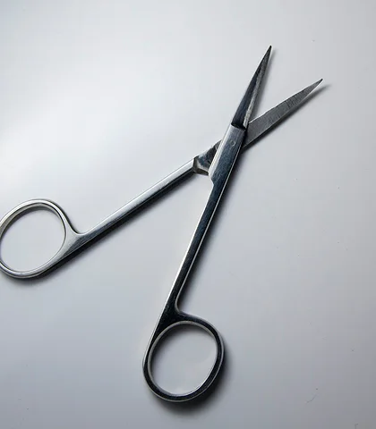 Steel surgical scissors on a gray background