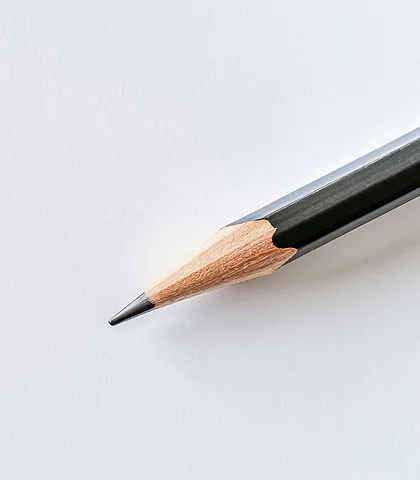 Sharpened pencil lying diagonally on white paper